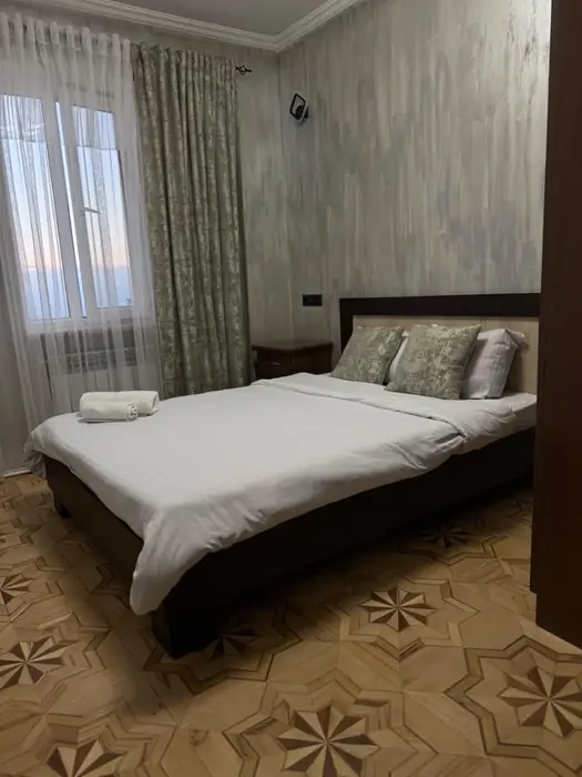 Double bed with white linen and a window over the valley