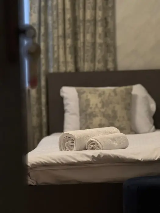 Rolled towels laid out on a made bed